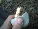 Using a piece of flint to put notch in arrow.