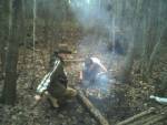 A couple of kids I bring to the forest to teach, Joe and Brian, at my campsite. You can see my debris hut in the back. Joe is coaxing a well-burned...