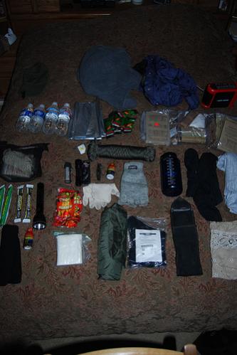 car kit
Inner Sanctum  (see other pic)
cap
fleece jacket
goretex shell
emergency battery charger
water
space blanket
3 mre's with heaters
gatorade powder
pepper mace
flashlight w/ spare batteries
5 hour energy drink
100' of 1/4" rope
gloves
water bottle
polypro long johns
polypro shirt
light sticks (4)
flashlight
hand & toe warmers
balaclava
TP
rain/wind pants
goretex socks
Kershaw survival knife w/ compass, fishing kit, matches inside
bandana